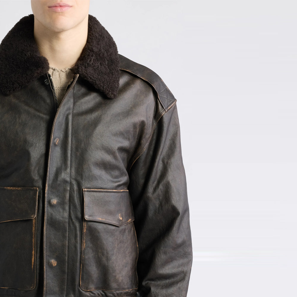 Close view of chocolate shearling collar, burnished lambskin shoulder panel and snap-covered closure