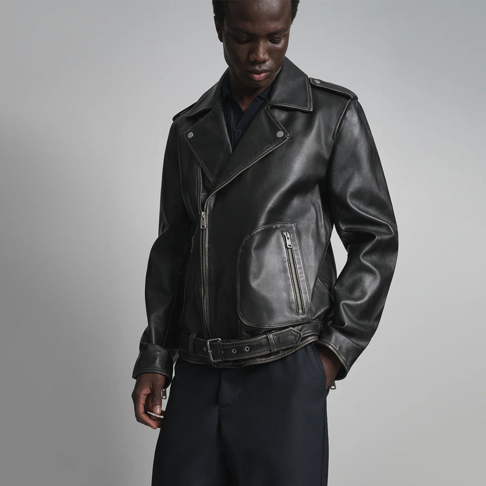Close front view of men’s sheepskin moto jacket featuring diagonal closure, notched collar and adjustable buckle belt