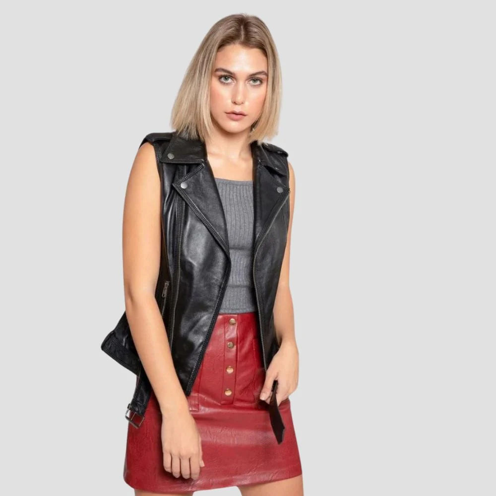 Women’s asymmetrical leather moto vest worn open over a gray top with adjustable waist belt and shoulder tabs visible