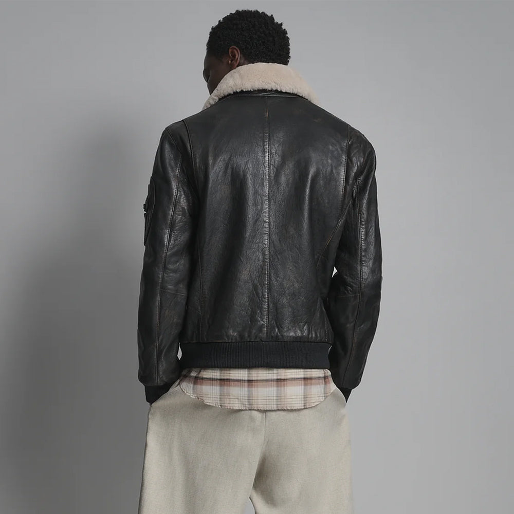 Rear view of black aviator bomber showing central seam, curved side shaping and rib-knit waistband