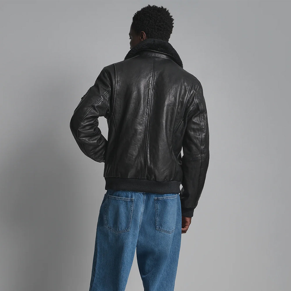 Rear view of black leather aviator jacket showing center-back seam, curved shaping panels and knitted hem