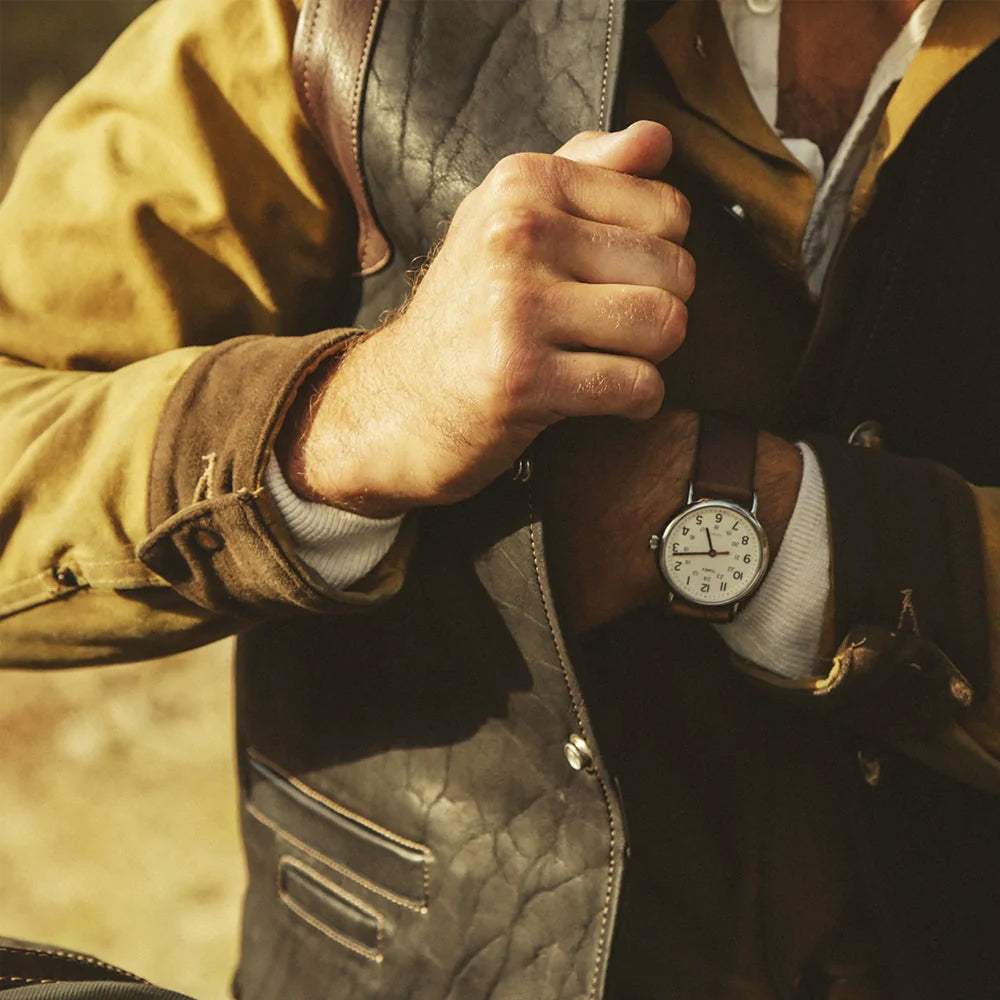 Close lifestyle view of black and brown cowboy leather vest layered over a rugged Western shirt