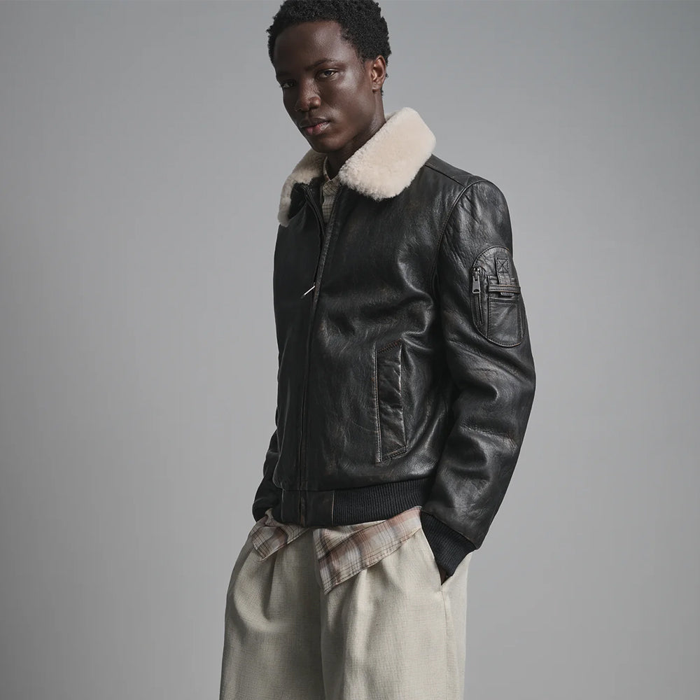 Black leather flight bomber showing sleeve zip patch, box-X utility tabs and polished natural grain