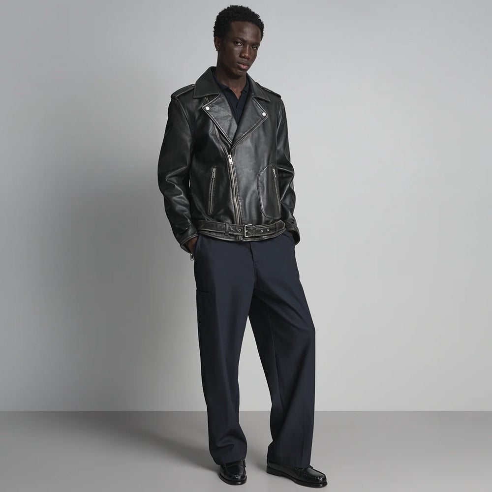 Men’s black motorcycle jacket outfit showing wide notched lapels, vertical pocket zippers and fitted waist belt