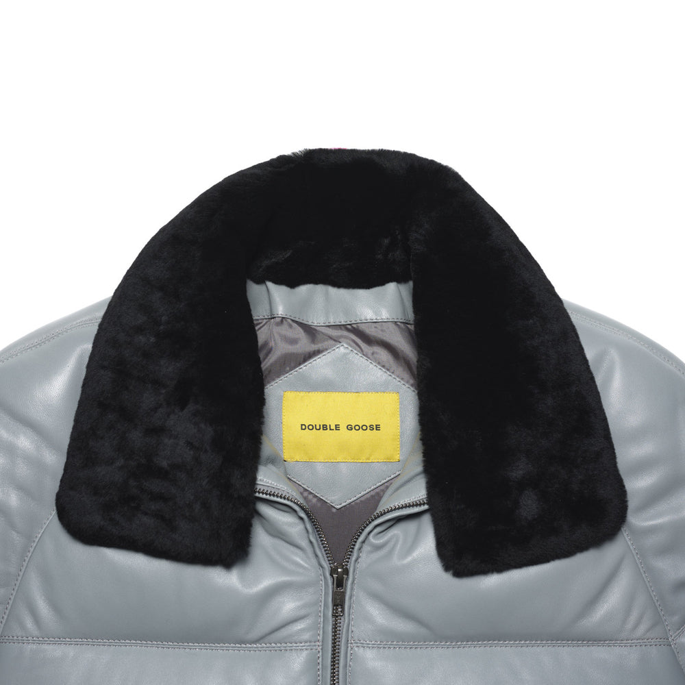 Close-up of detachable black sheep-wool trim and yellow Double Goose label on the light grey lambskin bomber