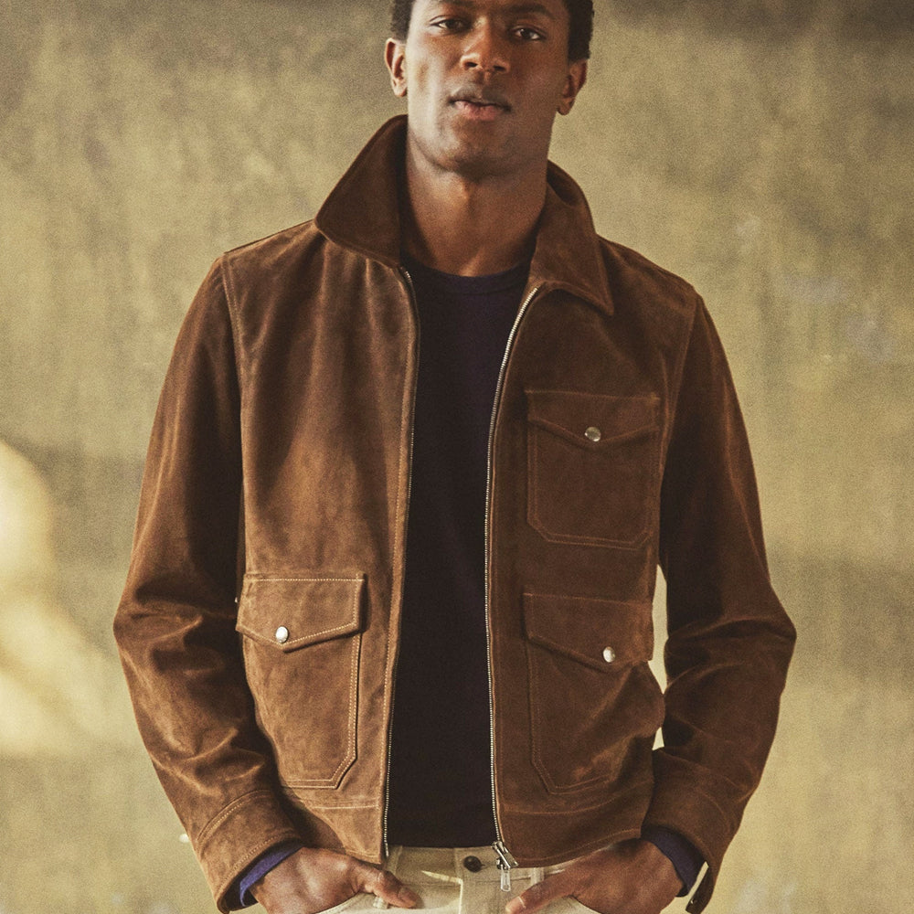 Model wearing the Blackwood men’s chocolate brown suede field jacket with three flap pockets and a two-way zipper