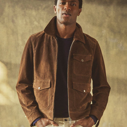 Model wearing the Blackwood men’s chocolate brown suede field jacket with three flap pockets and a two-way zipper