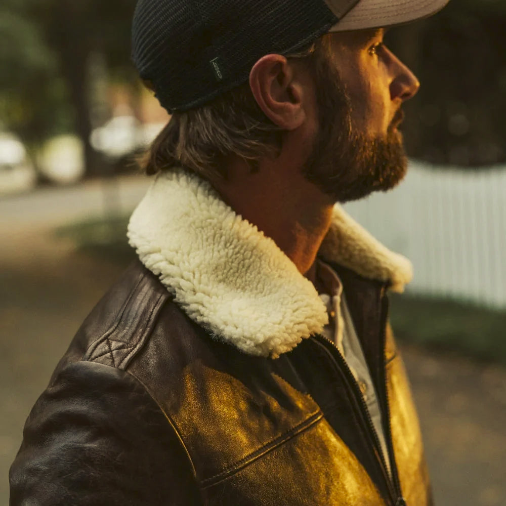 Close side view of genuine cream shearling collar on a brown cowhide aviator jacket