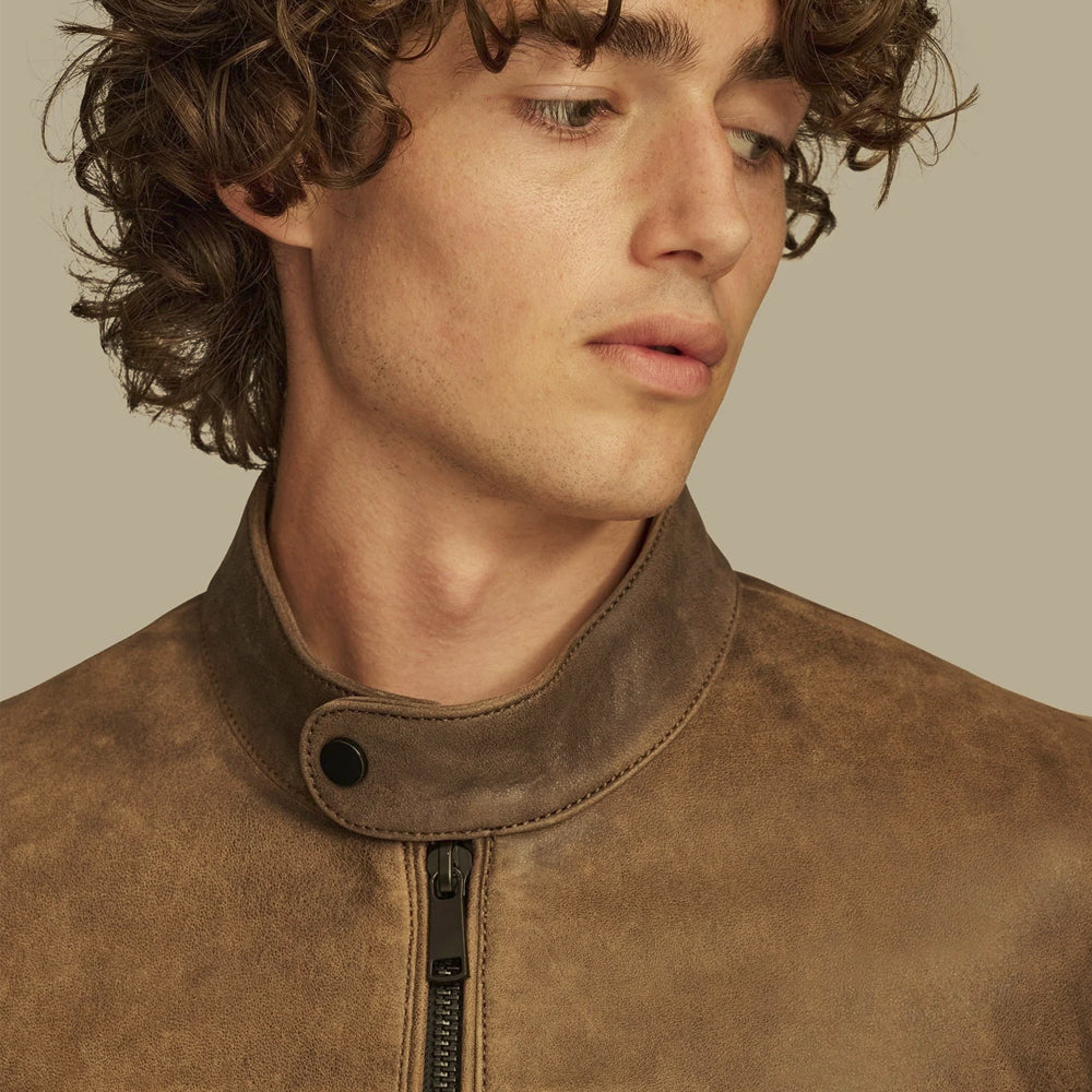 Close-up of rounded snap-tab stand collar on a distressed brown leather café racer jacket