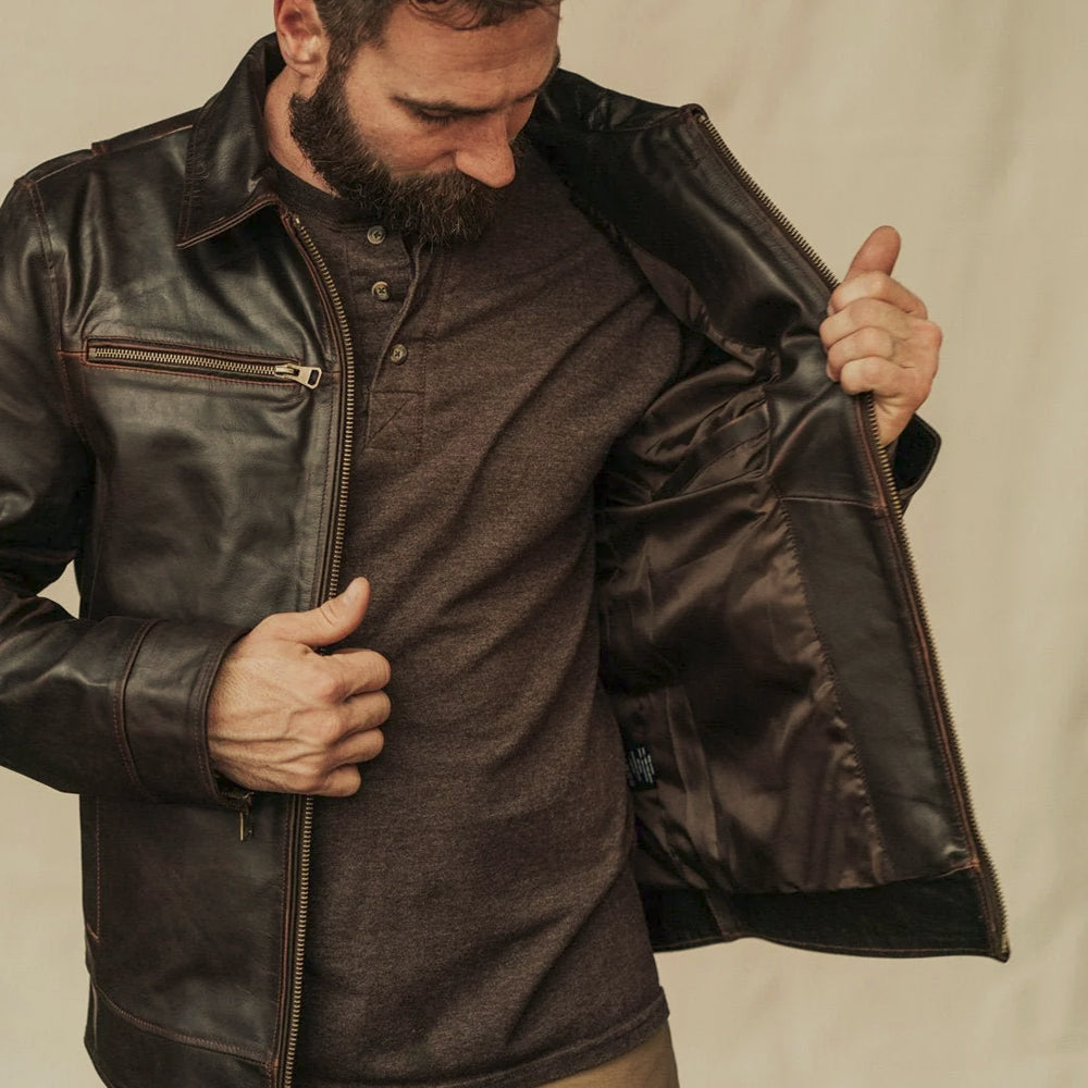 Open brown leather utility jacket displaying its smooth dark lining and concealed interior storage