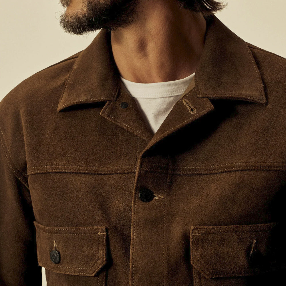 Close-up of the suede trucker jacket’s wide point collar, chest yoke, tonal stitching and buttoned flap pockets