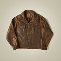 Front flat lay of a burnished brown cowhide trucker jacket with brass snaps, chest flaps and welt hand pockets