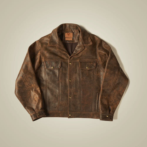 Front flat lay of a burnished brown cowhide trucker jacket with brass snaps, chest flaps and welt hand pockets