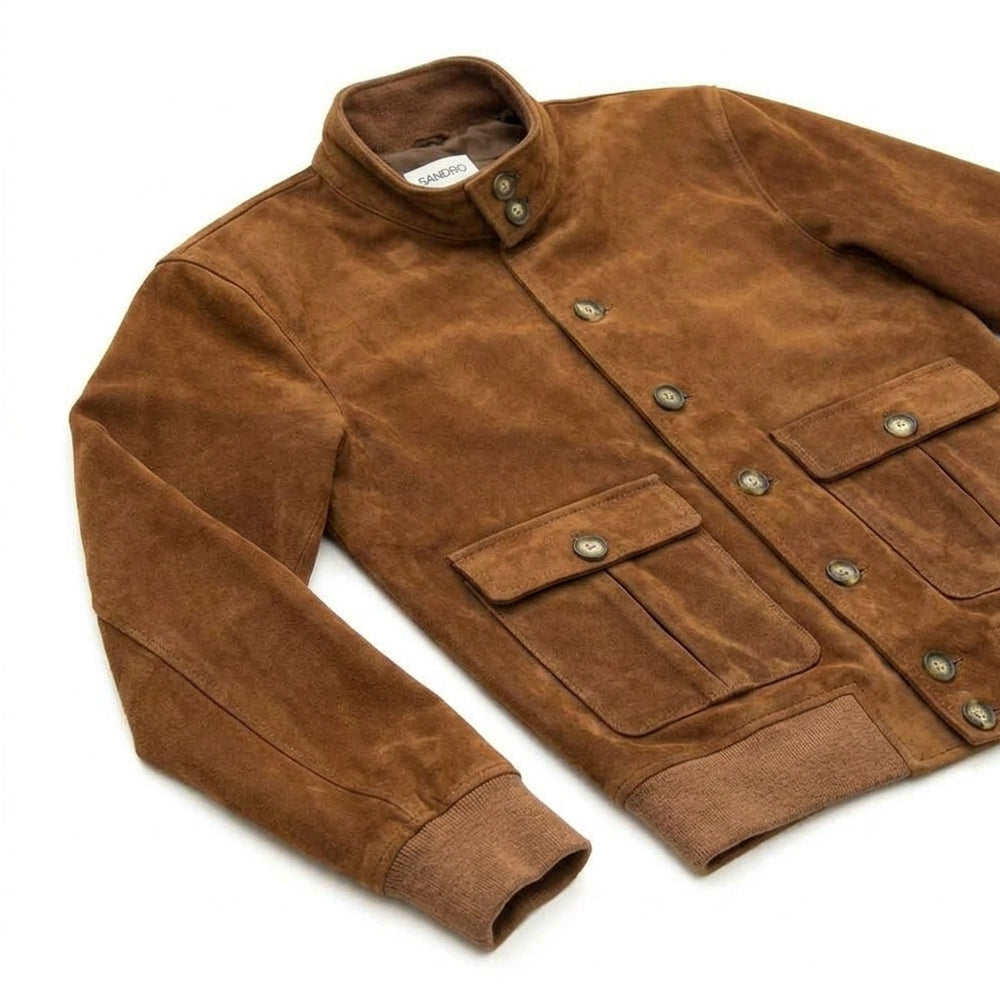 Angled detail of the button-front suede A-1 jacket with stand collar, patch pockets and rib-knit cuffs