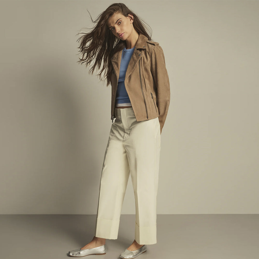 Full-length styling view of a camel-taupe double-rider jacket worn open with wide lapels and shoulder epaulettes.