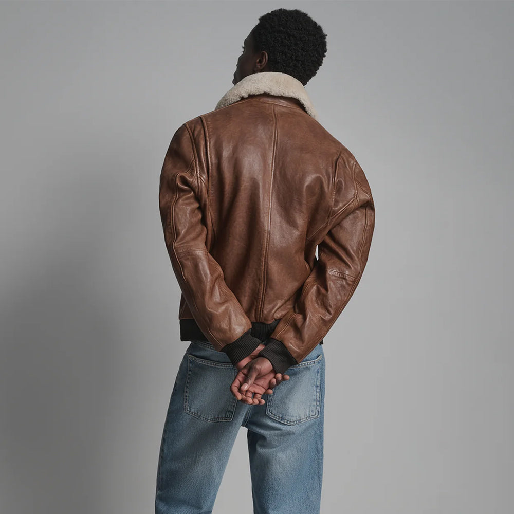 Back view of chestnut leather flight bomber showing center seam, smooth paneling and dark knitted waistband