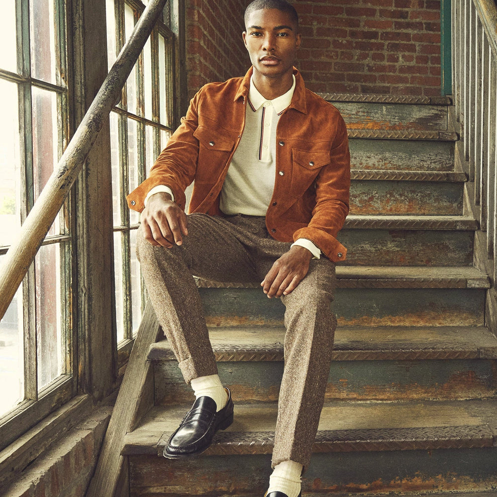 Man wearing the Copper Ridge cognac goatskin suede trucker jacket with brown trousers and black loafers