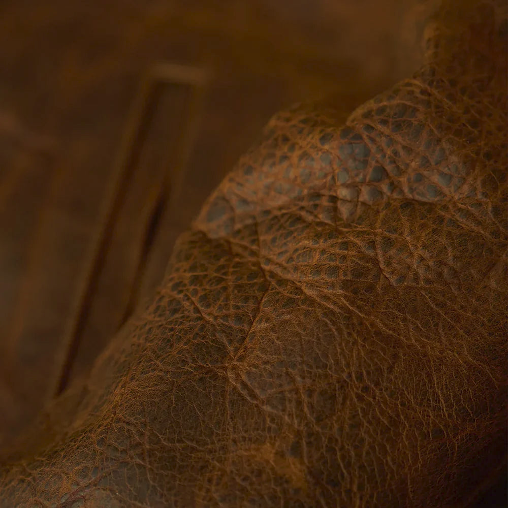 Macro close-up of brown crazy horse leather showing its waxed grain, pull-up shading and vintage creases