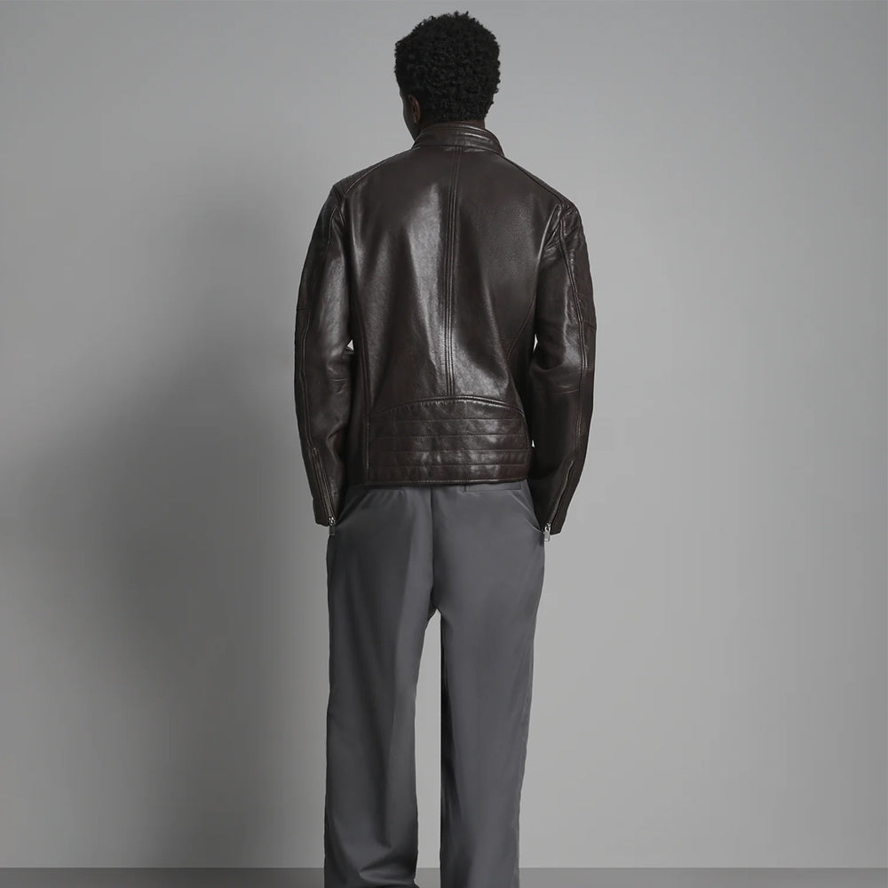 Rear view of dark brown quilted moto jacket showing center seam, curved panels and channel-stitched lower back