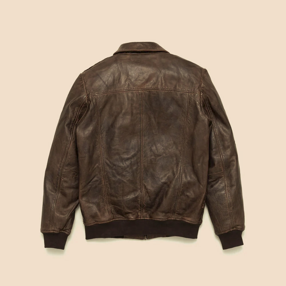 Rear view of distressed brown leather bomber showing shoulder yoke, center seam and knitted waistband