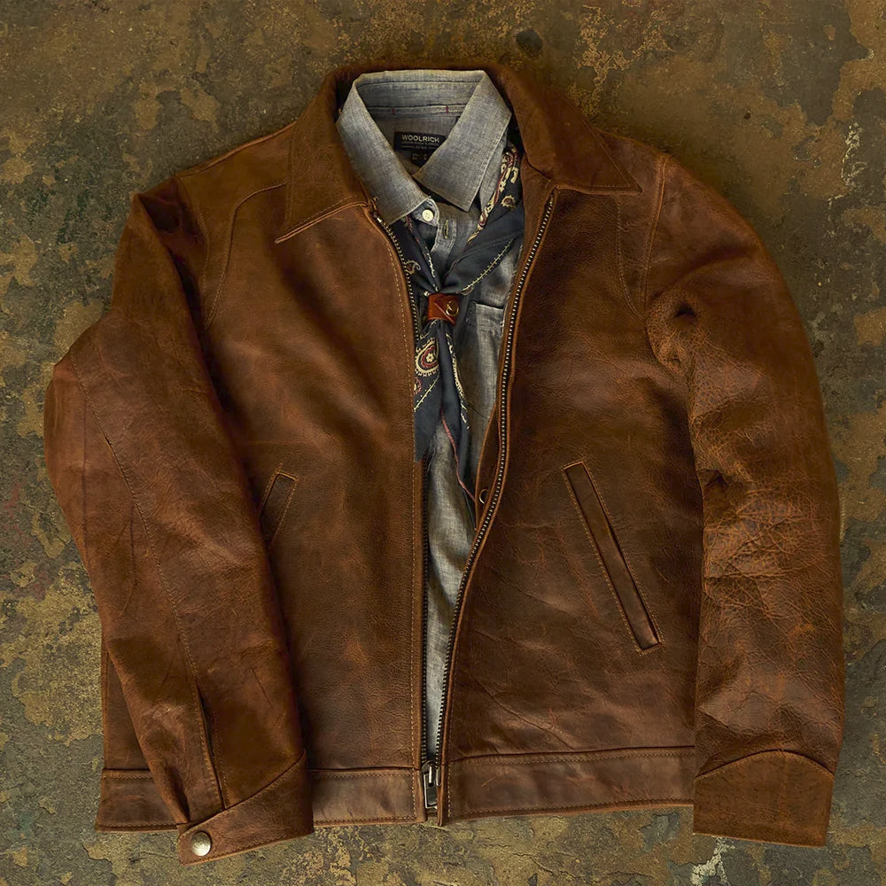 Open styled view of the distressed brown zip jacket layered over a chambray shirt and patterned neckerchief