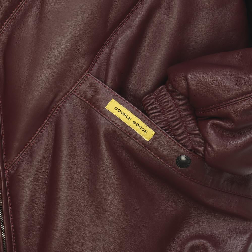 Angled burgundy leather welt pocket with branded snap, yellow Double Goose tab and elasticated cuff
