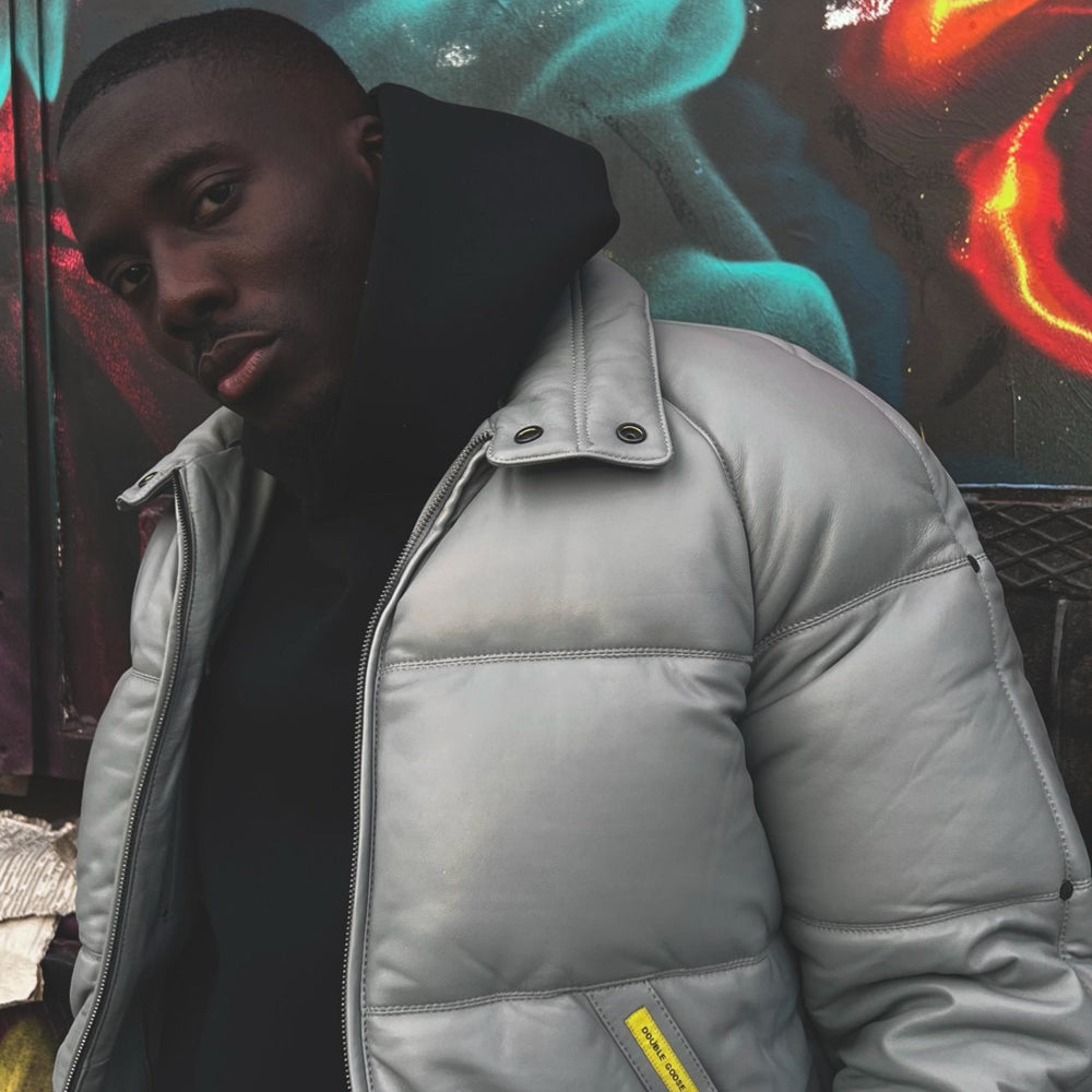 Close view of a man wearing the light grey horizontal-quilted Double Goose bomber without its wool trim