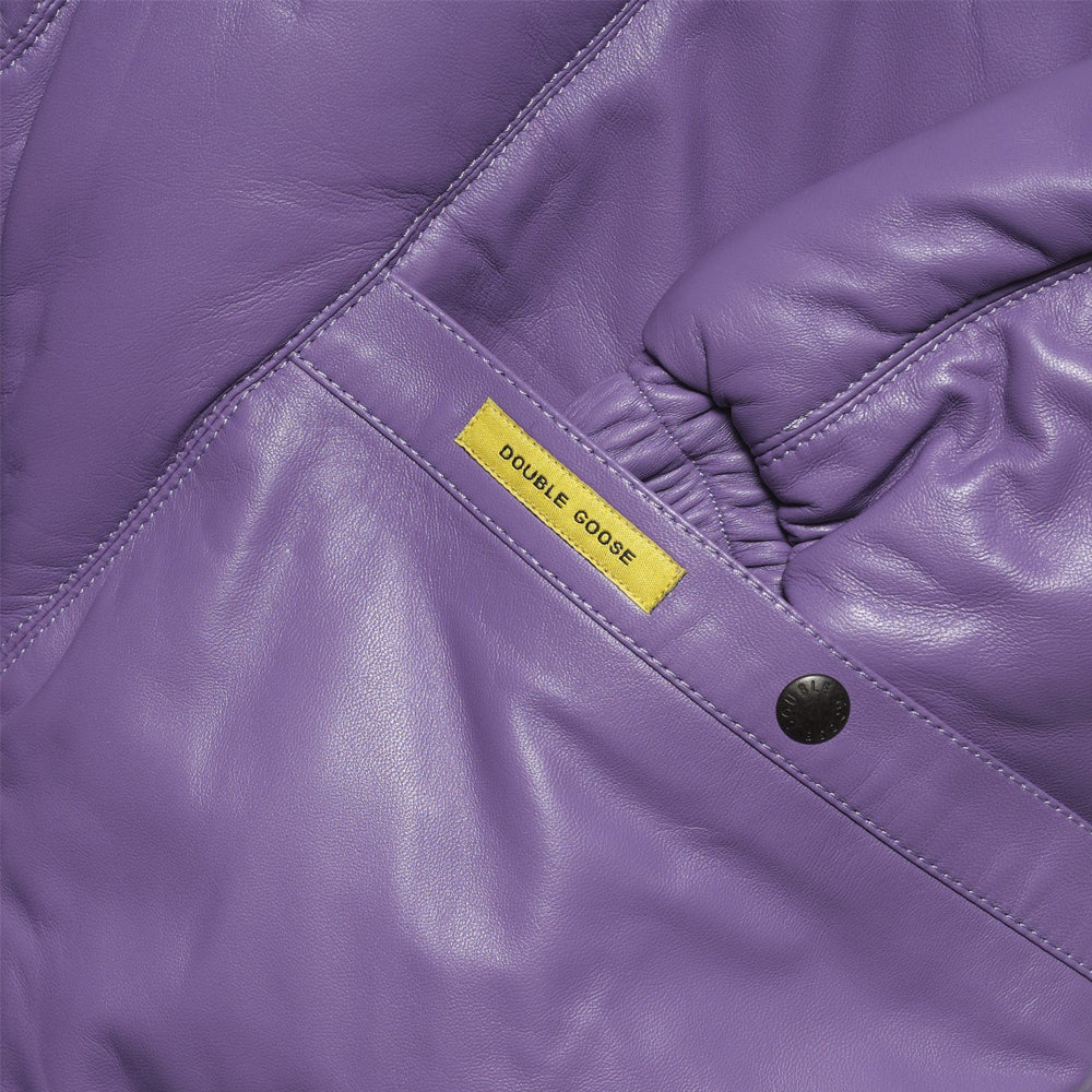 Close view of angled snap pocket, tonal lambskin stitching and yellow Double Goose branding tab