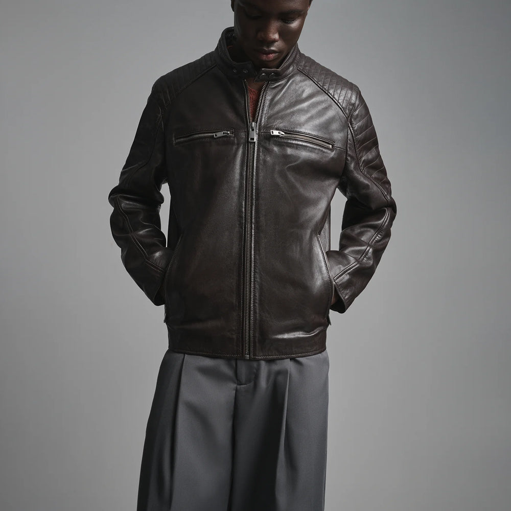 Close view of four-pocket sheepskin motorcycle jacket featuring chest zippers, angled hand pockets and ribbed shoulders