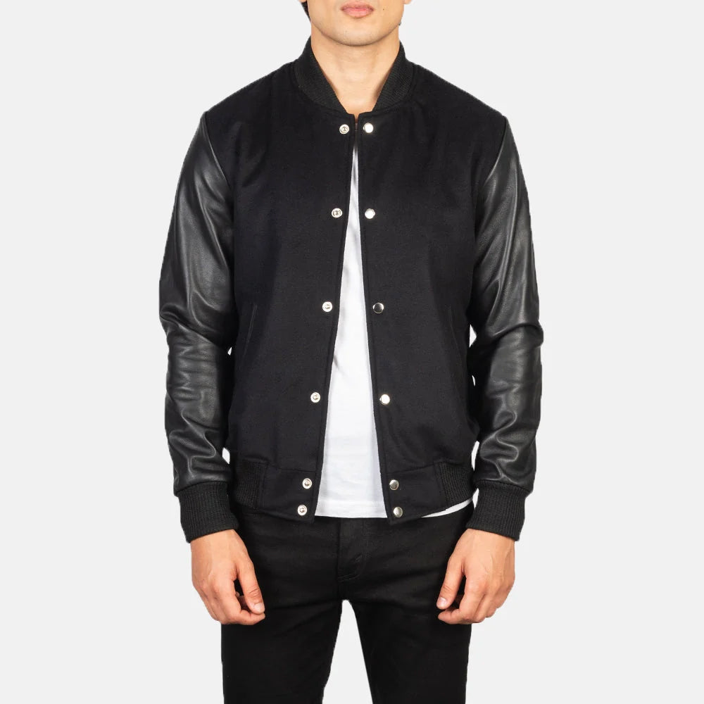 Open front view of men’s black varsity bomber jacket with leather sleeves and silver snap buttons
