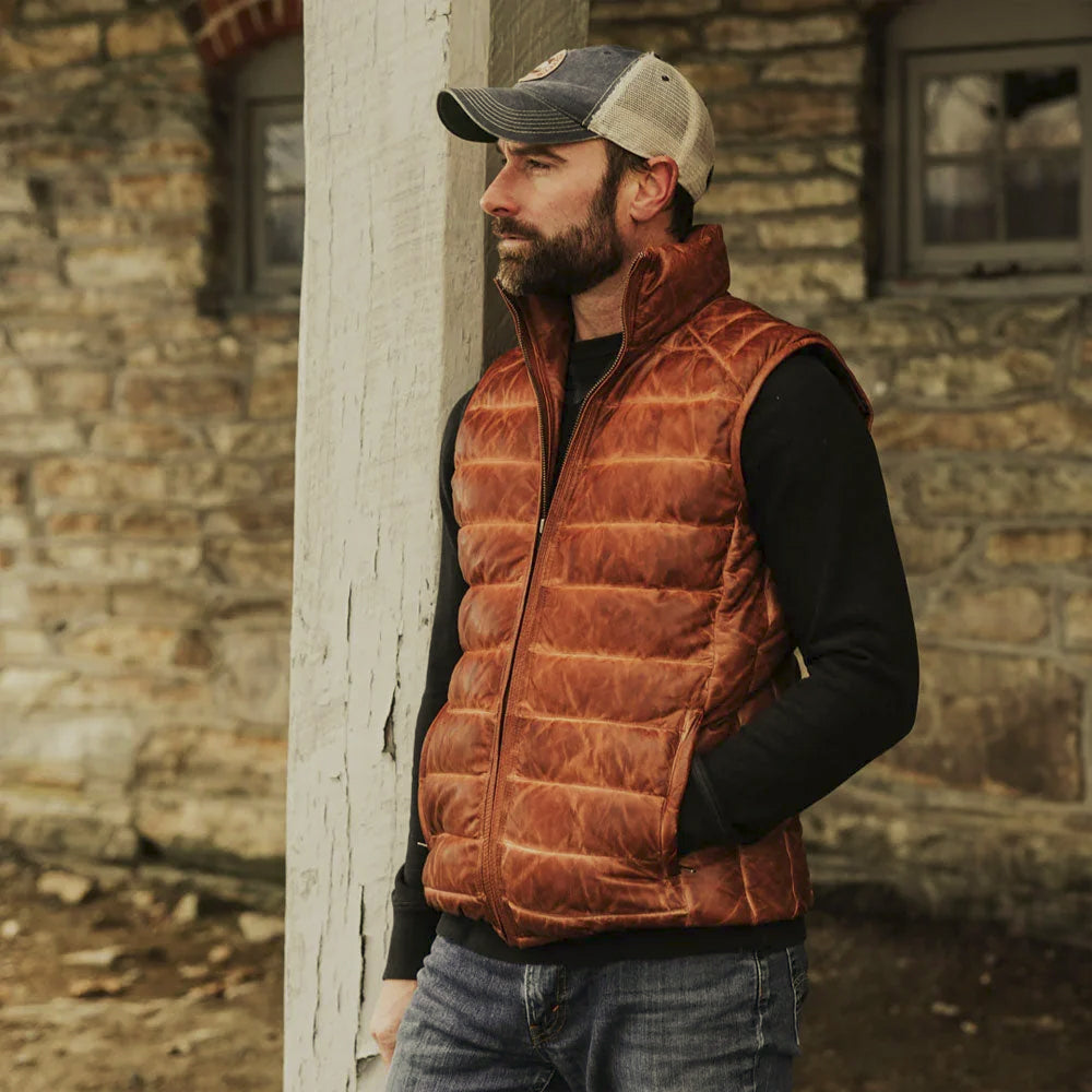 Men’s bubble-quilted leather gilet worn over a black sweatshirt with denim for cool-weather outdoor layering