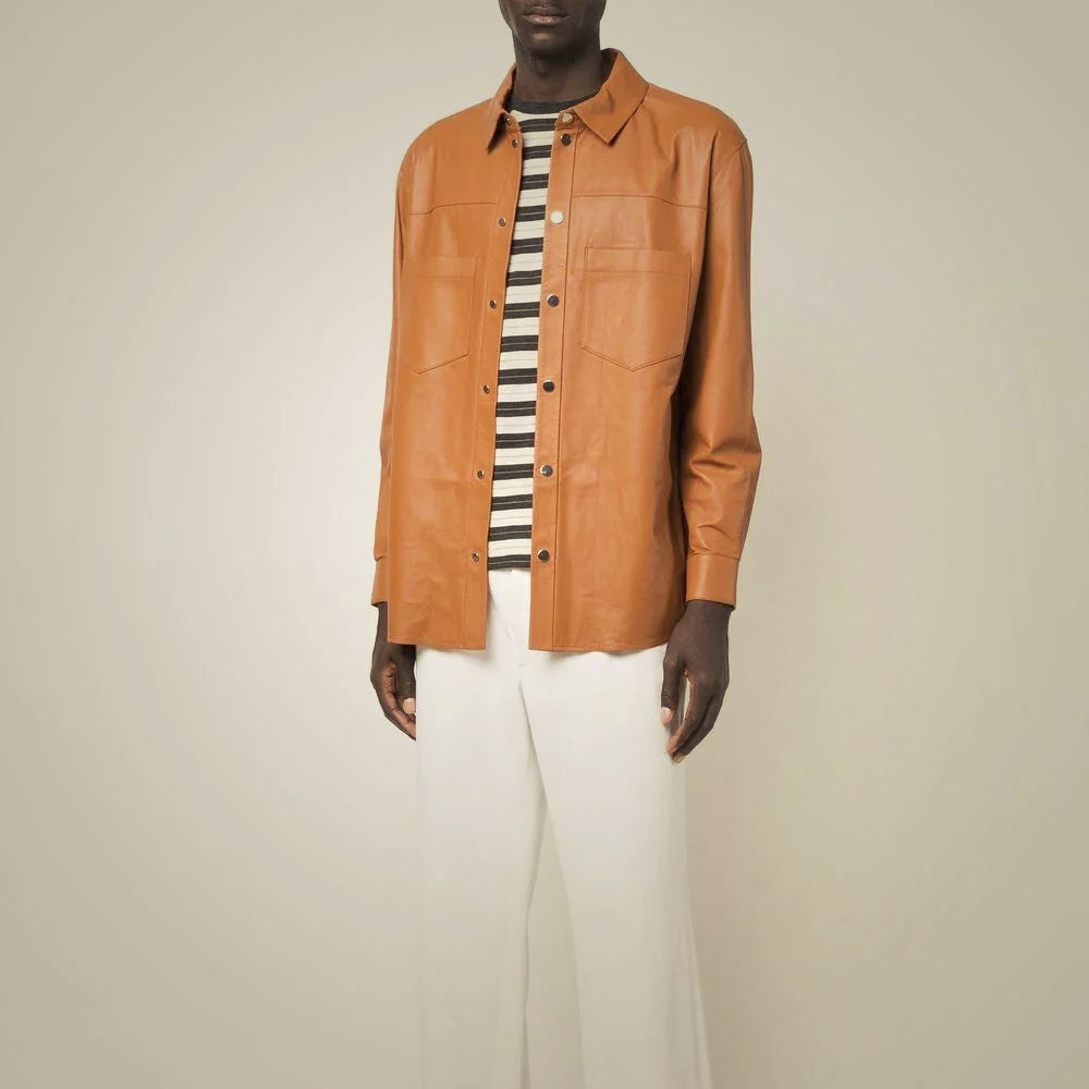 Male model wearing a caramel-brown sheepskin leather overshirt open over a striped T-shirt with cream trousers
