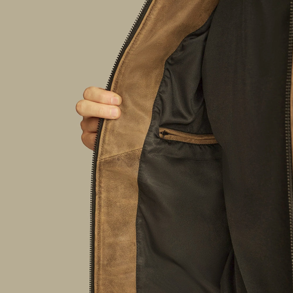 Interior of men’s brown cowhide jacket showing smooth black lining and leather-trimmed security pocket