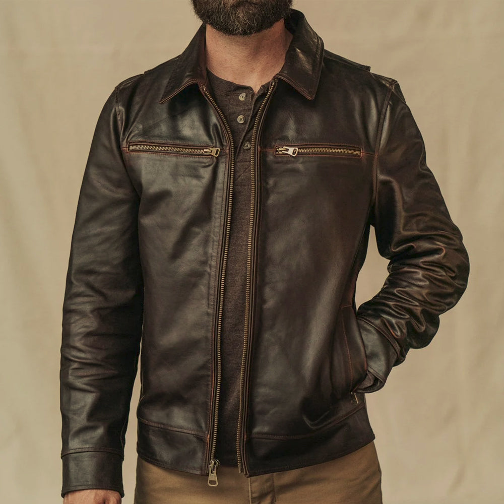 Men’s fitted distressed brown leather utility jacket styled with a henley shirt and neutral trousers