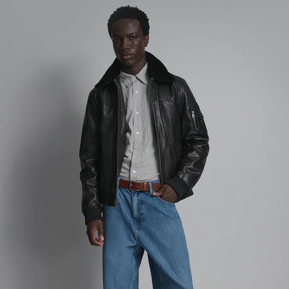 Men’s G-1-inspired black leather flight jacket worn open with tonal shearling collar and sleeve pocket