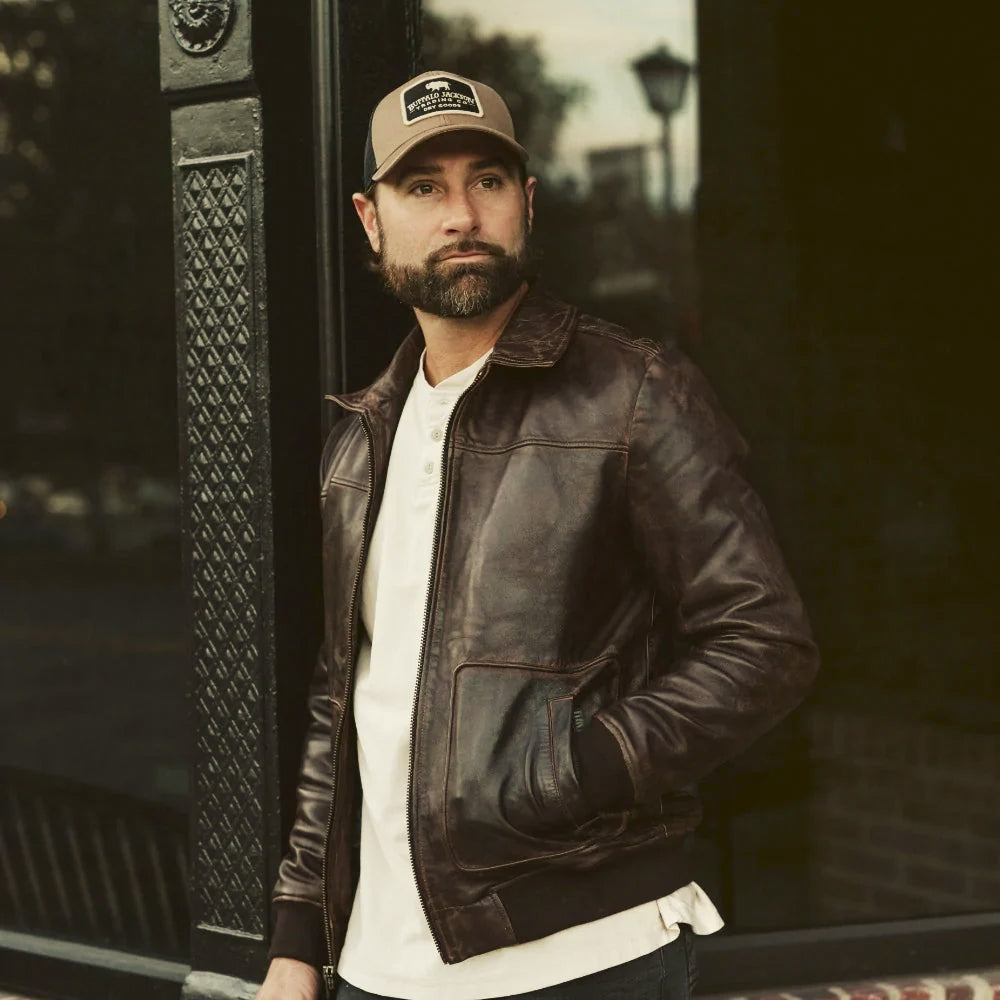 Men wearing a hand-burnished brown leather bomber with shirt collar and vertical-entry patch pockets