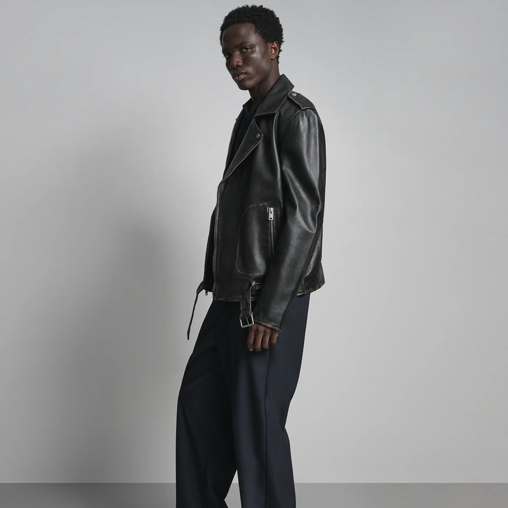 Side profile of men’s leather biker jacket with shoulder epaulette, rounded pocket panel and silver belt buckle