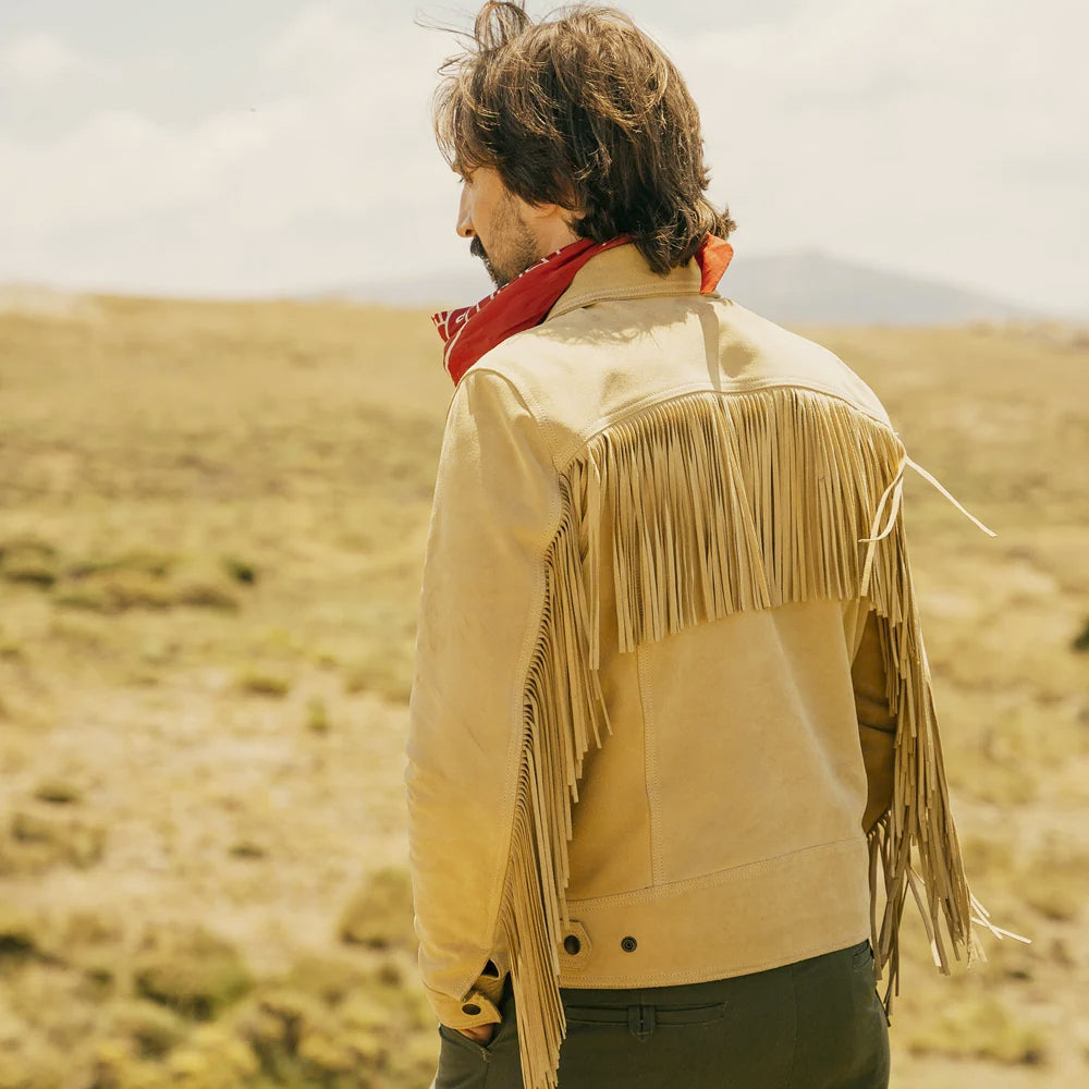 Man wearing a light-tan cowboy nubuck jacket with long fringe across the curved back yoke and sleeves