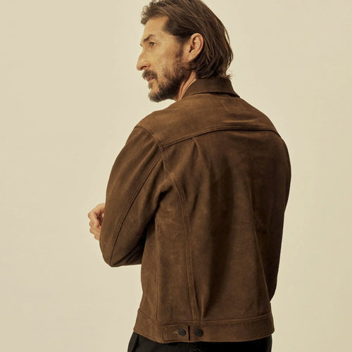 Rear three-quarter view of the brown goatskin suede jacket showing its shoulder yoke, vertical seams and waist tabs