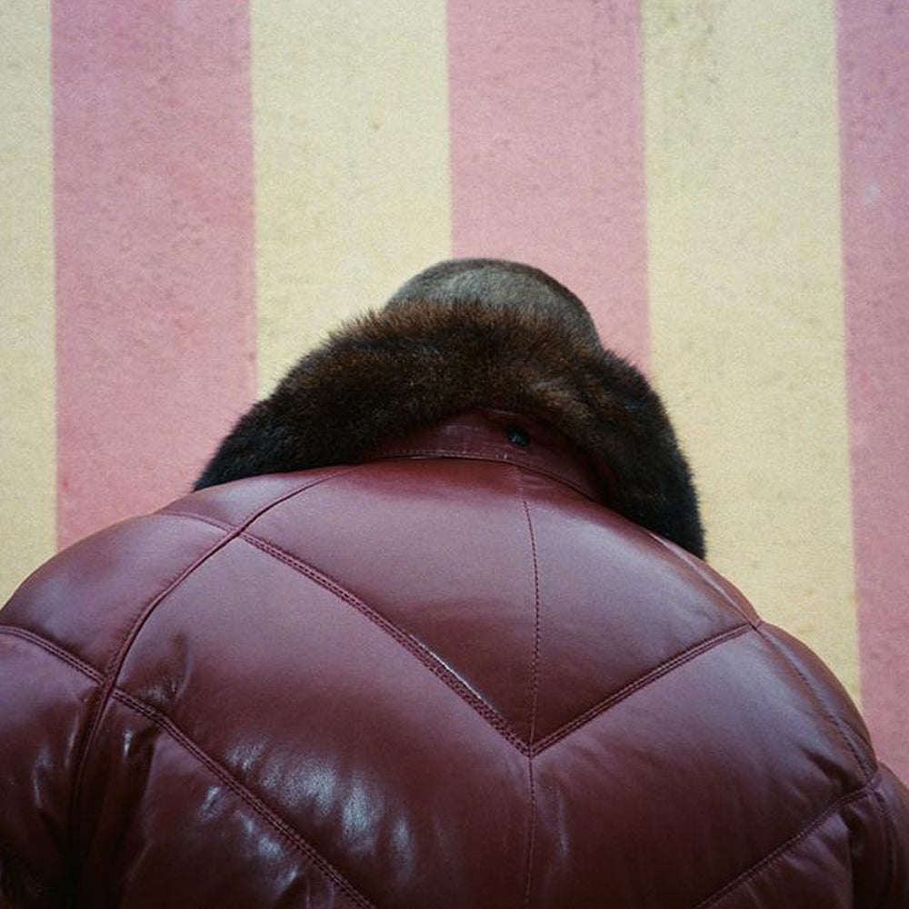 Worn rear close-up of the oxblood Double Goose jacket showing padded shoulder panels and precise chevron seams