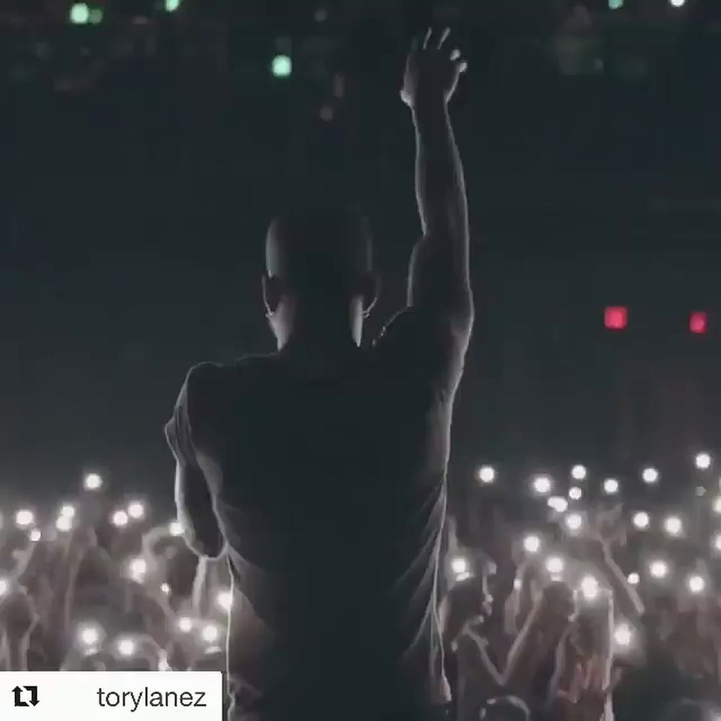 Live performance footage appearing to show Tory Lanez in a cognac Goose Country V-Bomber with woodland camouflage panels and black fur collar.