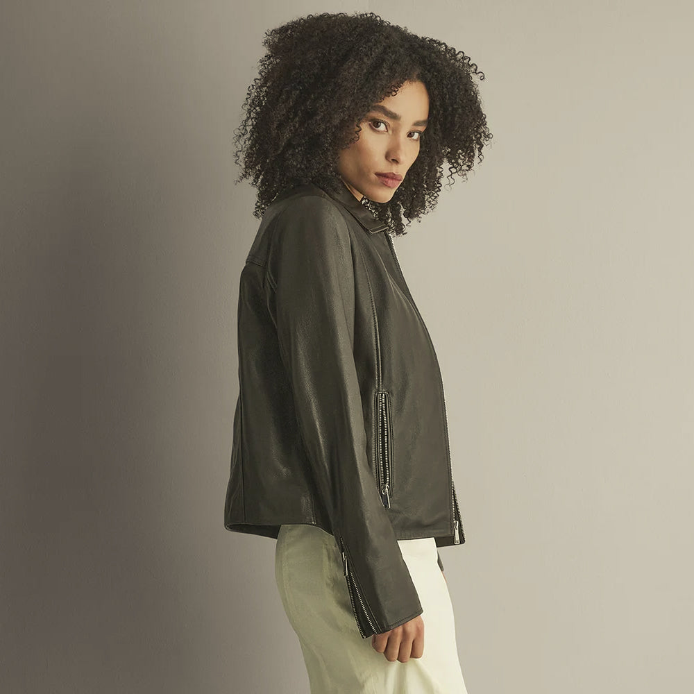 Side profile of a relaxed lamb leather shirt jacket highlighting the smooth panels, vertical pocket and gusseted zip cuff.