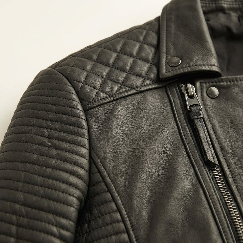 Close-up of sheepskin moto jacket showing diamond shoulder quilting and channel-stitched sleeve