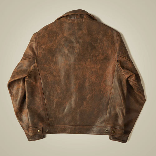 Back flat lay of the vintage brown leather trucker jacket showing a center seam, curved panels and adjustable hem tabs