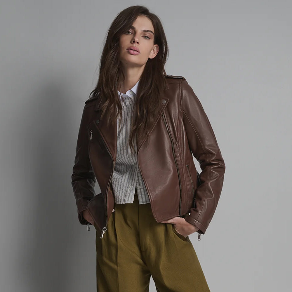Female model styling open-front brown grain leather moto jacket with metallic zip pockets and notched collar.
