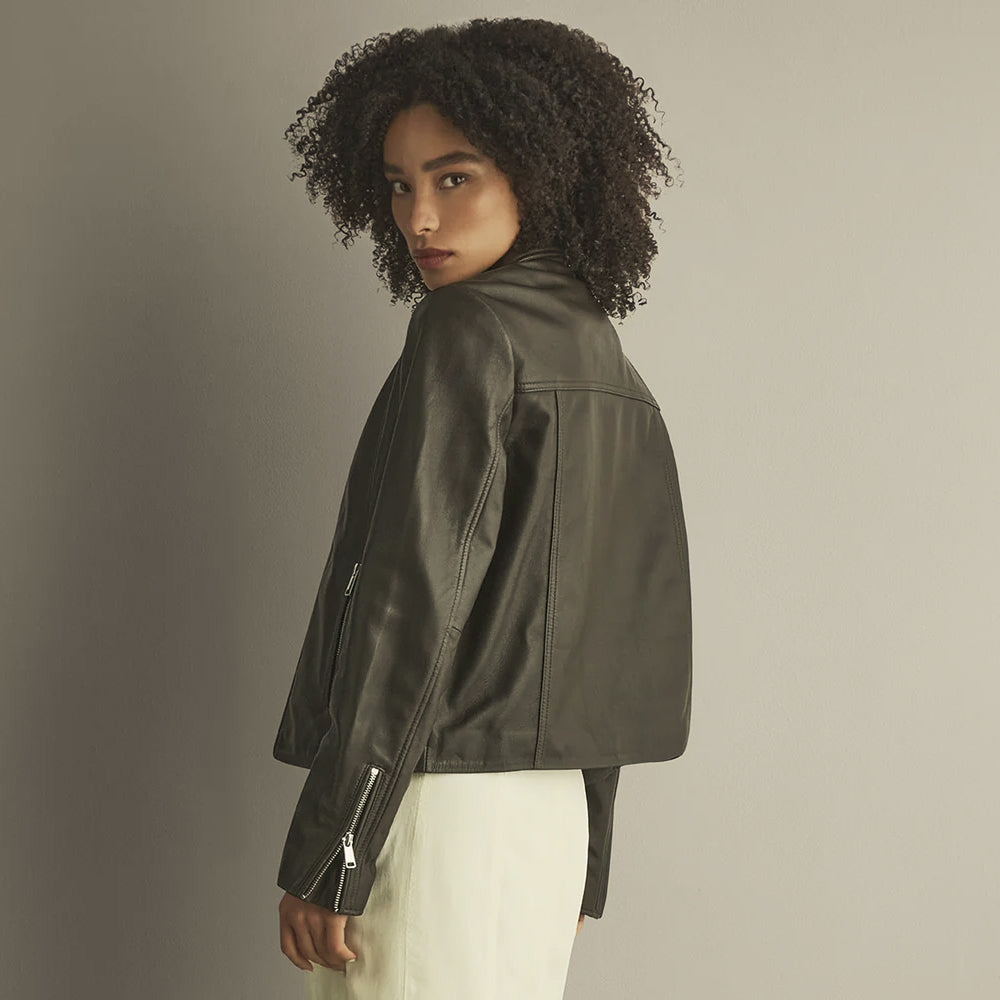 Rear three-quarter view of a dark brown leather overshirt showing its shoulder yoke, center seam and relaxed short silhouette.