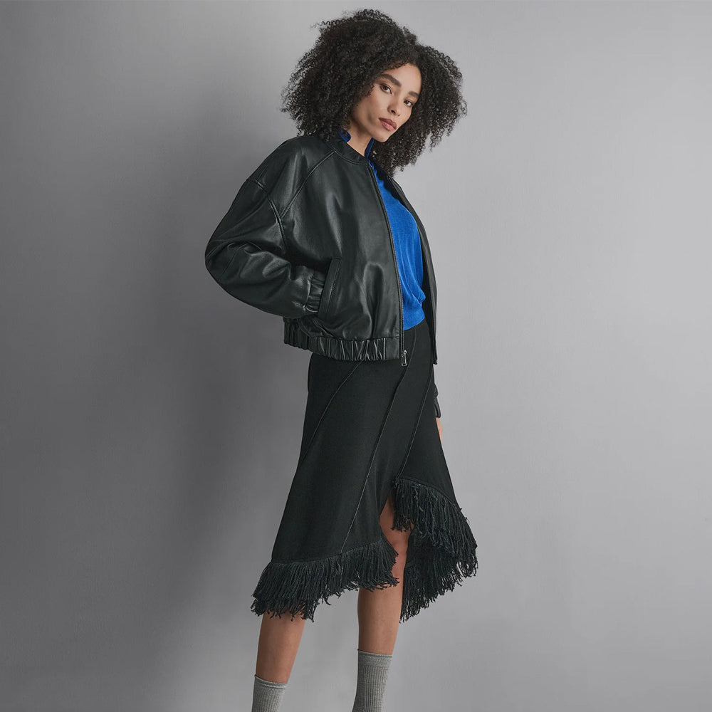 Side view of a women’s drop-shoulder leather varsity jacket with diagonal welt pocket and rounded sleeve volume.