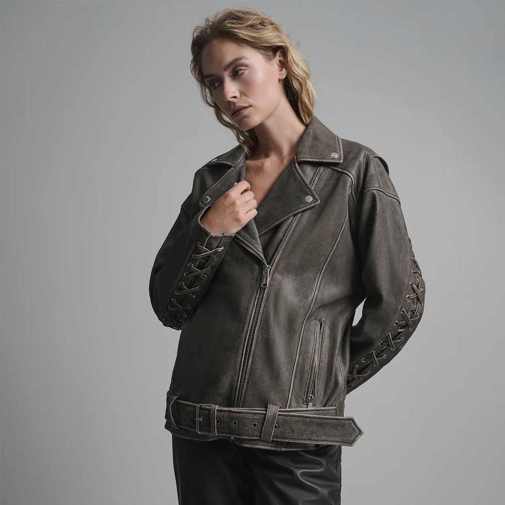 Close-up of lace-up cross-stitching and metallic grommet hardware on the sleeves of a women's vintage moto jacket.