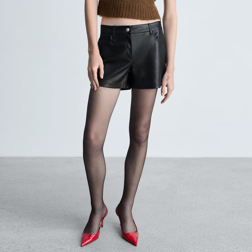 Close-up shot of short straight-leg cut on women's black lambskin mini shorts.