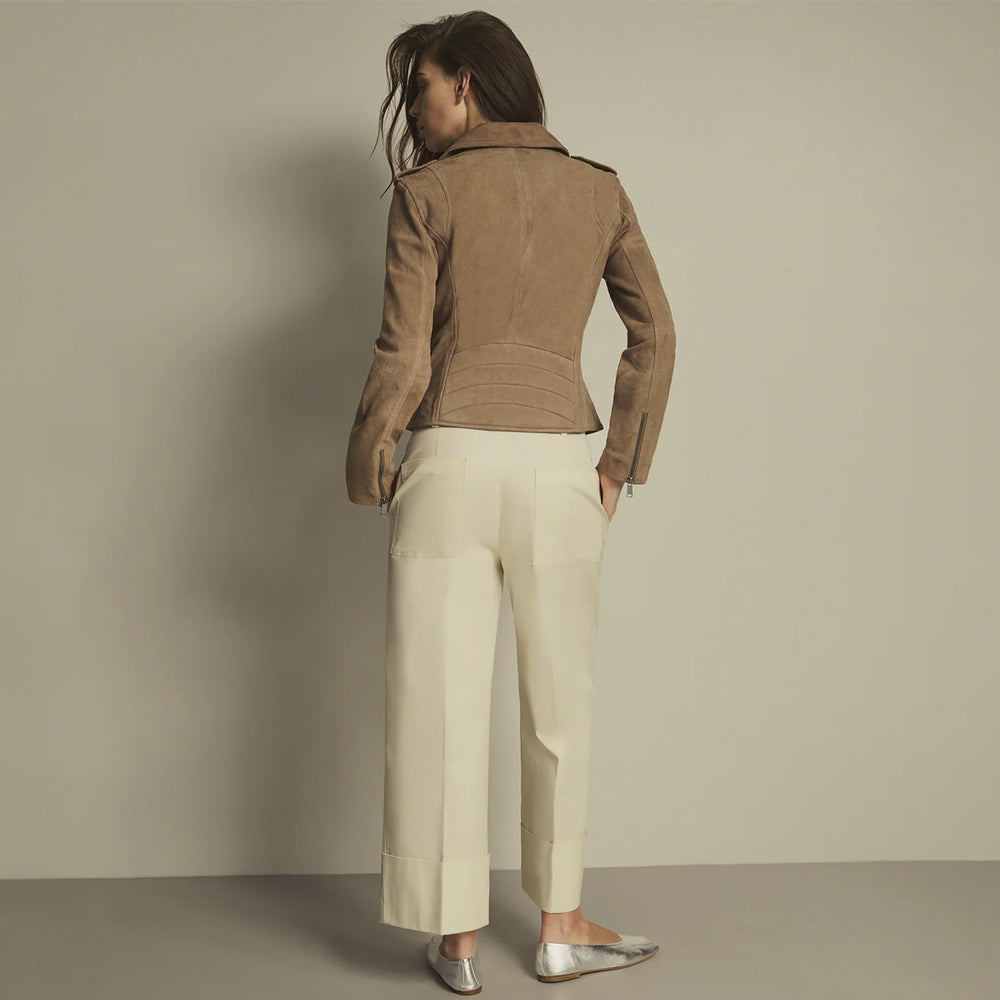 Rear view of a women’s taupe suede jacket with contour seams, curved quilted waist channels and zip cuffs.